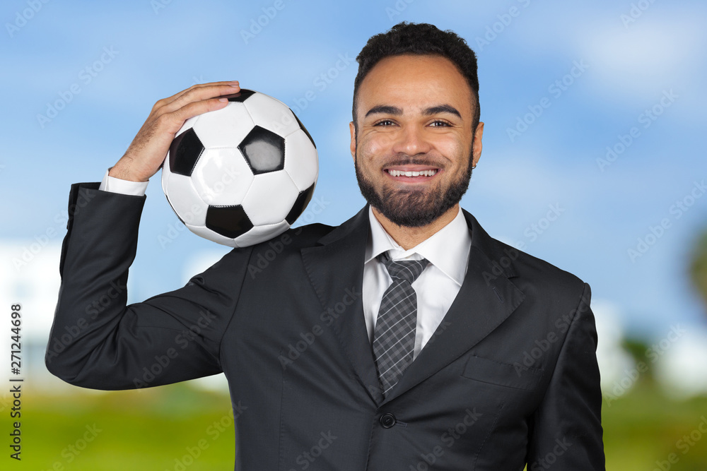 African businessman holding a soccer ball. Soccer trainer