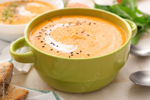 Pot of tasty cream soup on table