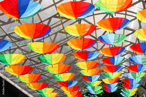 Many colored umbrellas for urban decoration. rainbow umbrellas on the roof.