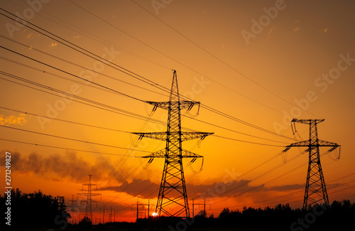 Silhouette High voltage electric towers at sunset time. High-voltage power lines. Electricity distribution station