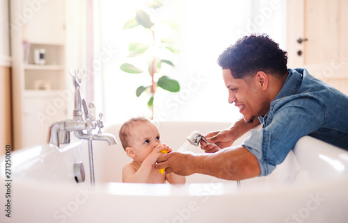 Fotografija Father washing small toddler son in a bathroom indoors at home.