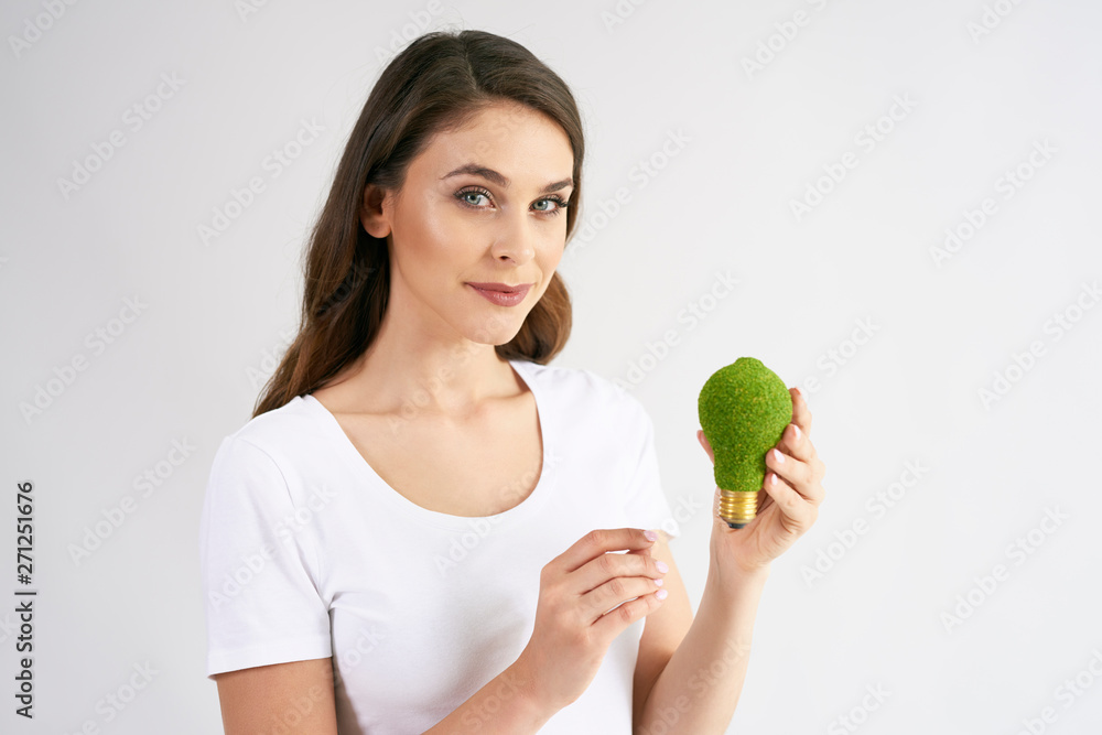 Front view of woman holding a energy efficient light bulb Front view of woman holding a energy efficient light bulb