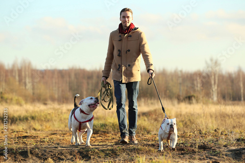 Photography Young happy european smiling and laughing walking in a field with two dogs