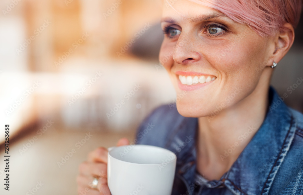 A close-up portrait of young attractive woman standing by window at home. A close-up portrait of young attractive woman standing by window at home.