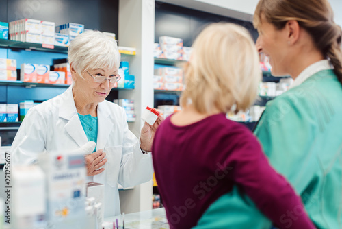 Obraz na płótnie Erfahrene Apothekerin berät Mutter mit Kind