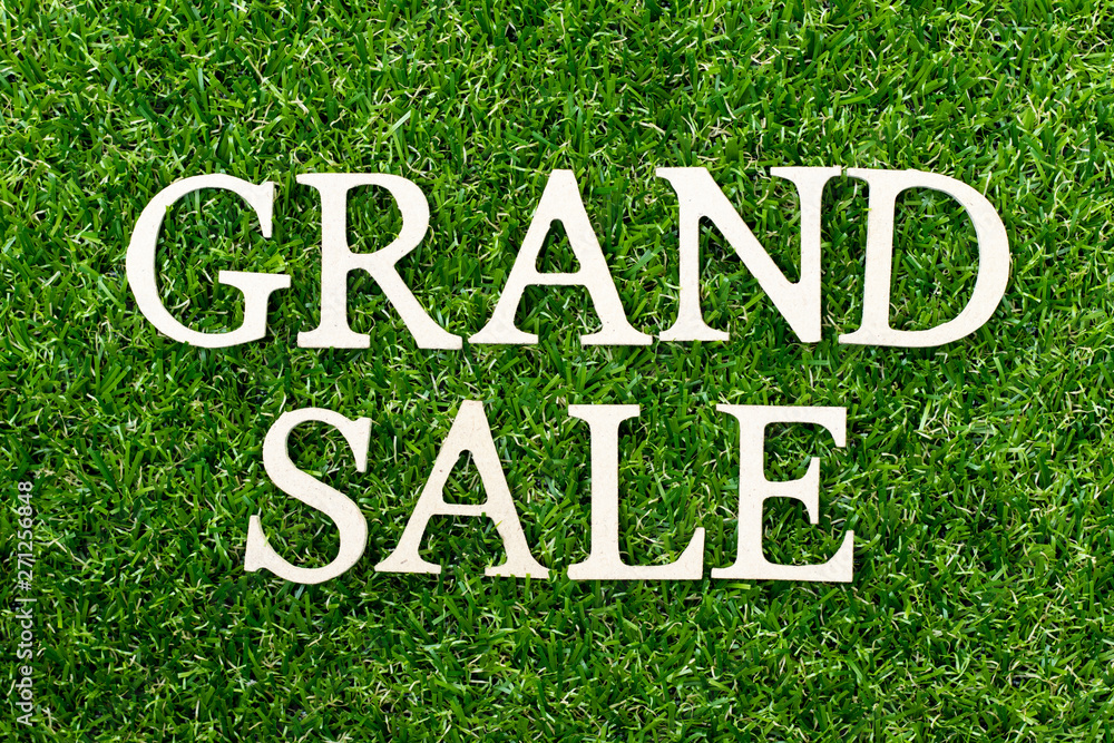 Wood alphabet letter in word grand sale on green grass background