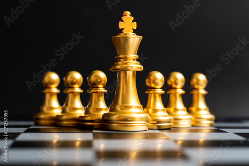 Gold king chess piece stand in front of pawn on black background  Concept of leadership  management 