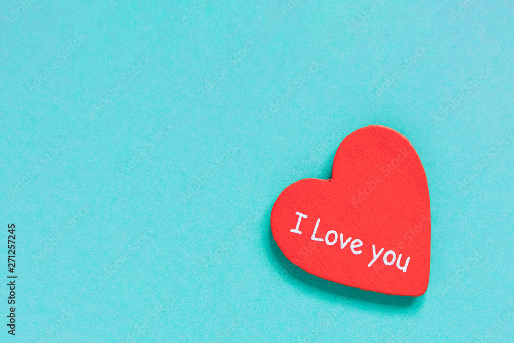 Fototapeta premium Red heart with text love you on blue background.