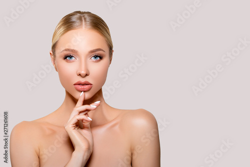 Foto Beautiful young Woman touches her face with her hand, perfect clean smooth well-groomed Skin
