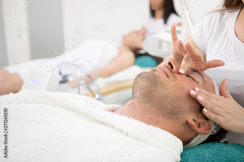 Man in cosmetic spa salon enjoy in facial massage