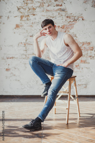 portrait of a young man in jeans and a sleeveless jacket © Мария Бучнева