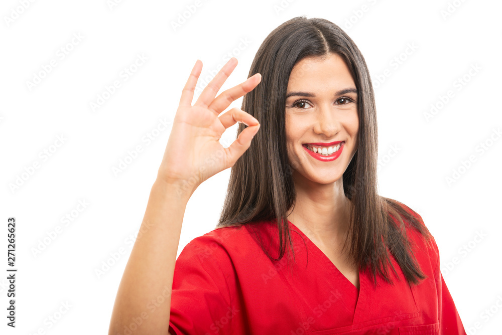 Portrait of beautiful nurse wearing red scrubs showing ok gesture Portrait of beautiful nurse wearing red scrubs showing ok gesture