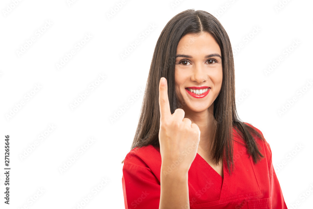 Portrait of beautiful nurse wearing red scrubs showing number one gesture Portrait of beautiful nurse wearing red scrubs showing number one gesture