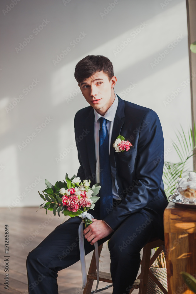 the groom with a bouquet in the room shows different emotions the groom with a bouquet in the room shows different emotions