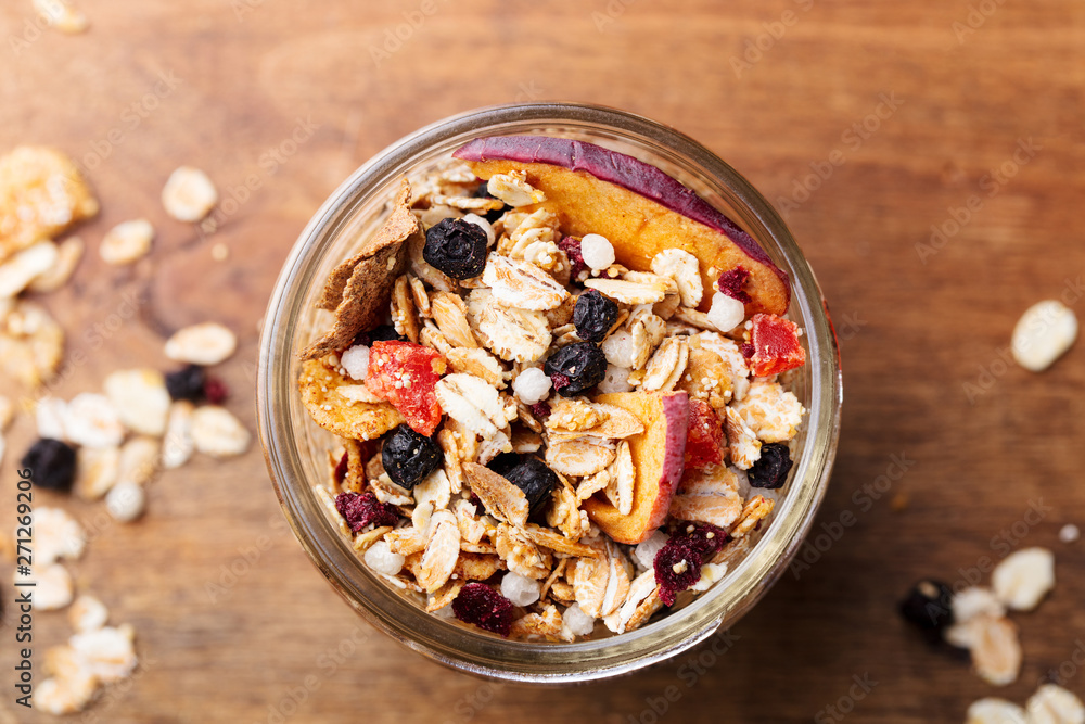 Granola, muesli in glass jar. Healthy breakfast. Organic oats with berries and nuts. Close up. Granola, muesli in glass jar. Healthy breakfast. Organic oats with berries and nuts. Close up.