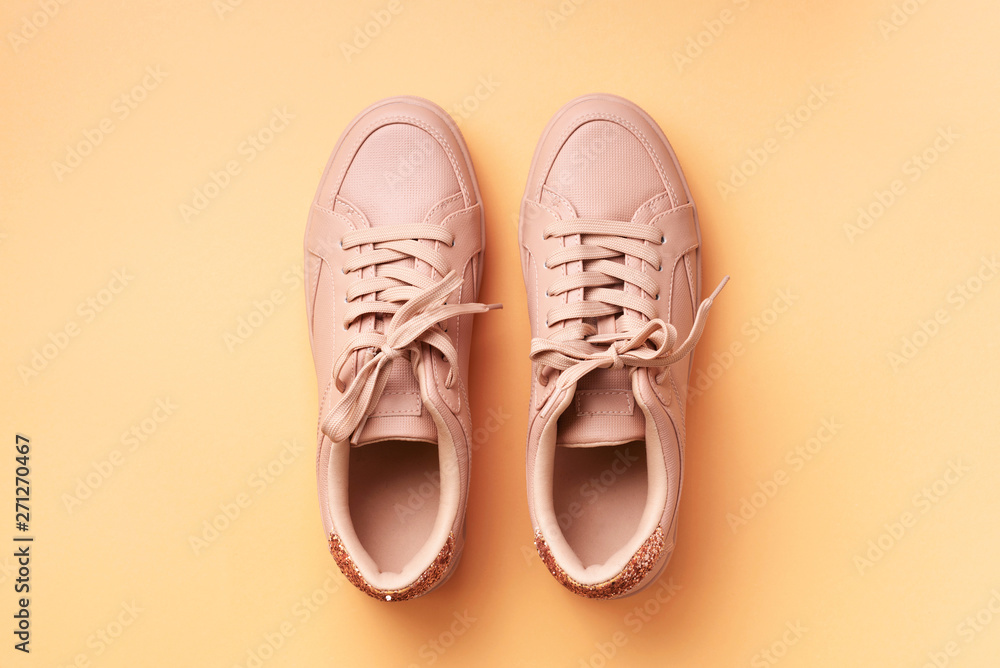 Woman fashion pink shoes on pink background with copy space. Top view. Flat lay. Fitness, sport concept. Nude female sneakers