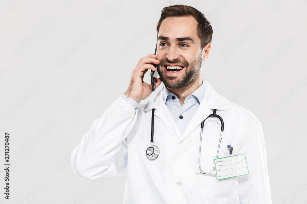 Portrait of smiling young medical doctor with stethoscope working in clinic and talking on cellphone Portrait of smiling young medical doctor with stethoscope working in clinic and talking on cellphone