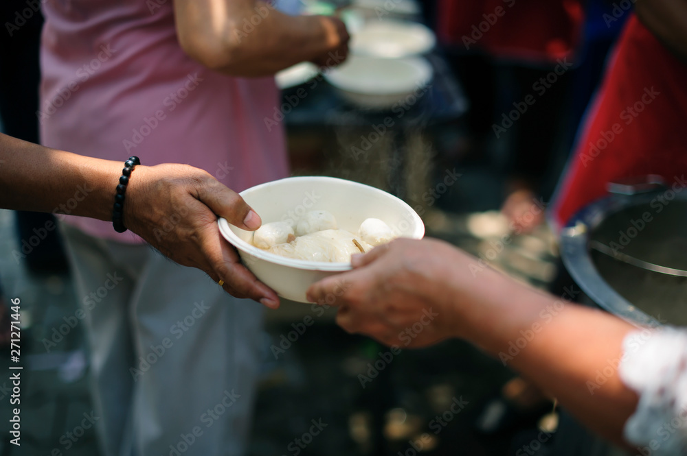 Hand-feeding to the needy in society : Concept of Feeding : Volunteers give food to the poor : donating food is helping human friends in society : Helping People With Hunger With Kindness