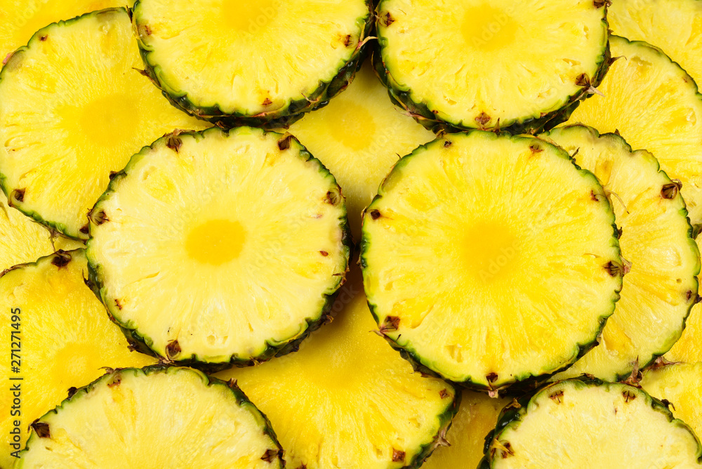 Pineapple juicy yellow slices background. Top view.