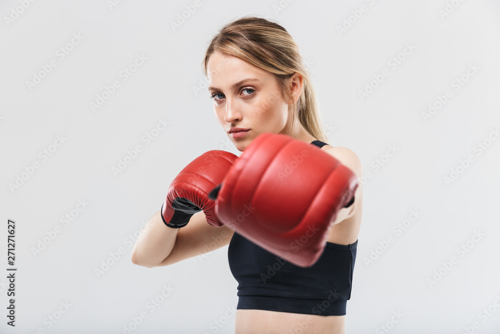 Image of european blond woman 20s dressed in sportswear and boxing gloves working out and during fitness in gym