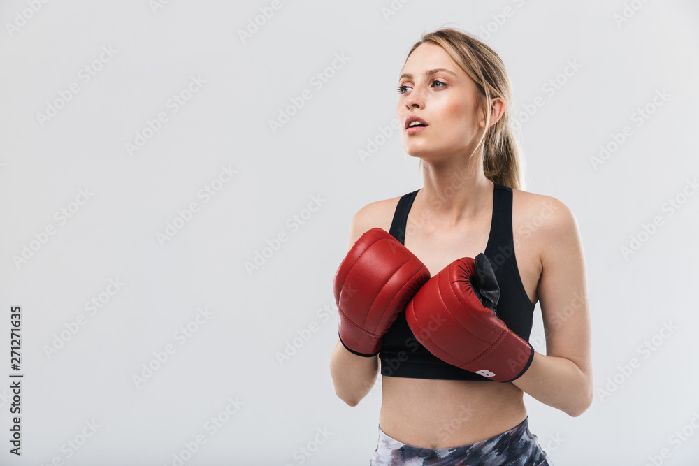 Image of gymnastic blond woman 20s dressed in sportswear and boxing gloves working out and during fitness in gym