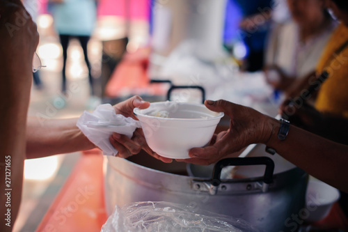 Hand-feeding to the needy in society : Concept of Feeding : Volunteers give food to the poor : donating food is helping human friends in society : Helping People With Hunger With Kindness