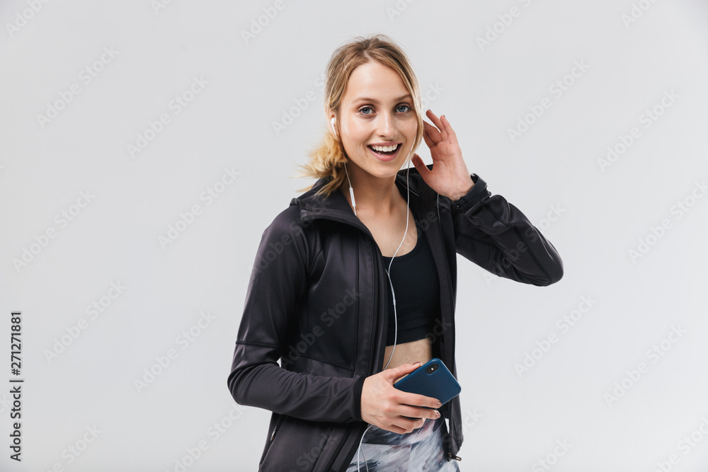 Image of beautiful blond woman 20s dressed in sportswear listening to music with headphones while running Image of beautiful blond woman 20s dressed in sportswear listening to music with headphones while running