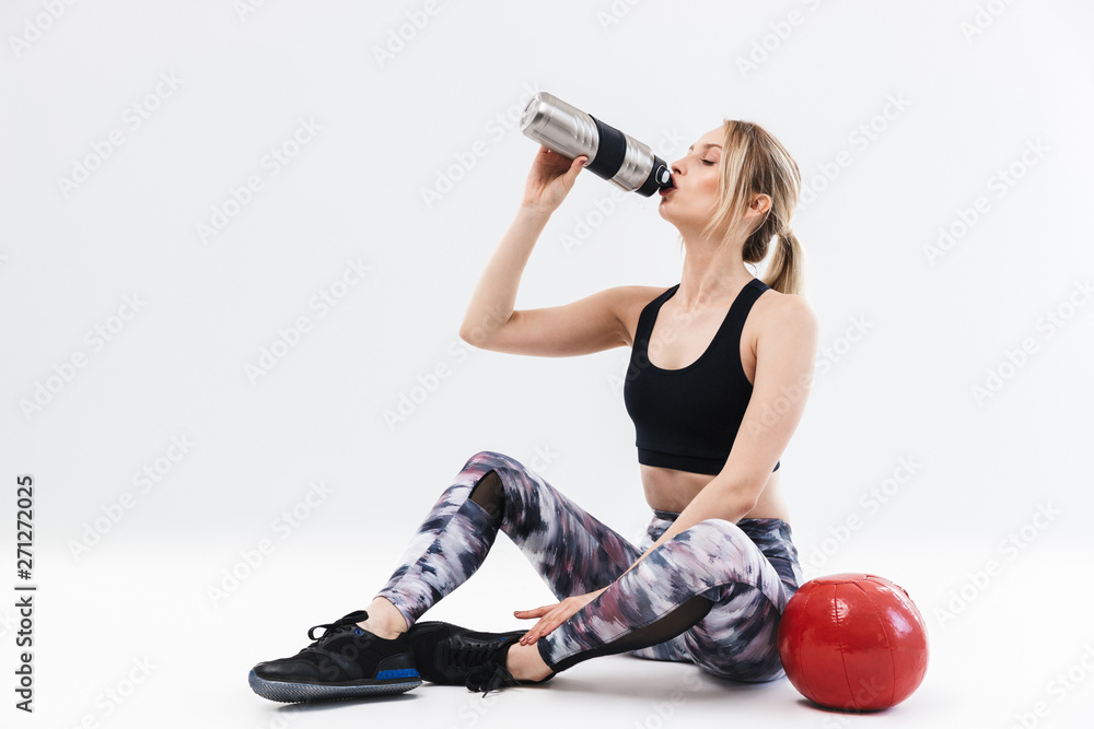 Image of athletic blond woman 20s dressed in sportswear working out and doing exercises with fitness ball Image of athletic blond woman 20s dressed in sportswear working out and doing exercises with fitness ball