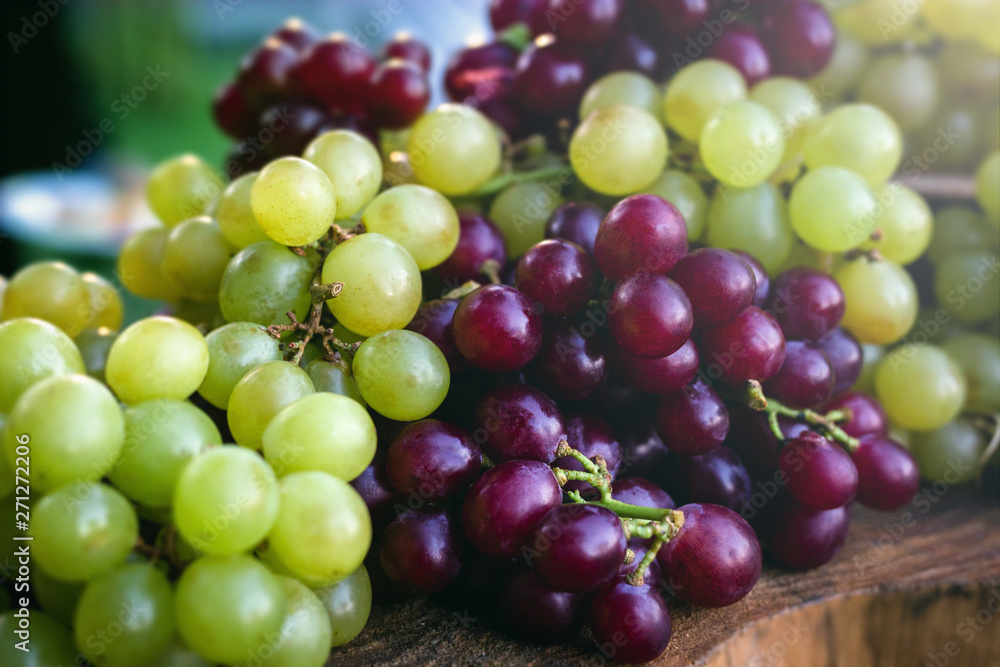 Concept of party or decoration with fruits. Beautiful assorted grapes on rustic wooden trunk, natural grapes direct from producer. Concept of party or decoration with fruits. Beautiful assorted grapes on rustic wooden trunk, natural grapes direct from producer.