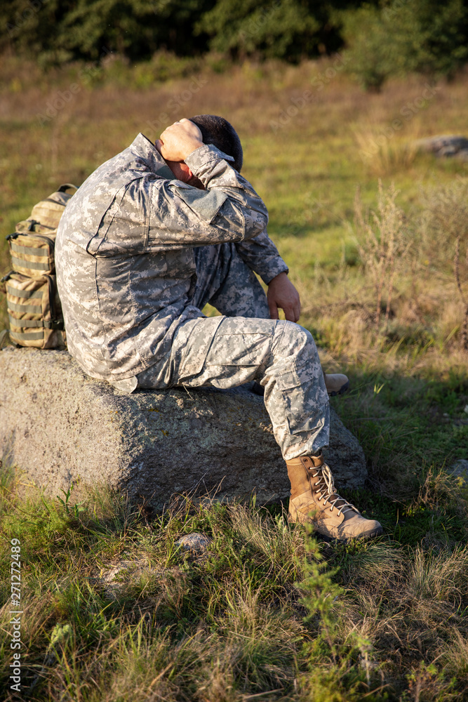 The soldier sits and rests. Sad soldier. Tired soldier.