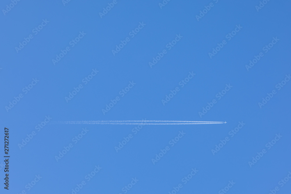 A High-resolution Image Of A Plane Flying Through The Clear Blue Sky Overhead, With A Trail Behind It. Mockup Template On The Topic Of Air Travel With Copy Space For Text. A High-resolution Image Of A Plane Flying Through The Clear Blue Sky Overhead, With A Trail Behind It. Mockup Template On The Topic Of Air Travel With Copy Space For Text.