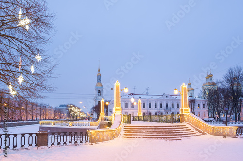 St. Petersburg in the Christmas holidays. The Krasnogvardeysky bridge at the confluence of the Griboyedov and Kryukov Canals near the St. Nicholas Cathedral in the evening illumination. Russia