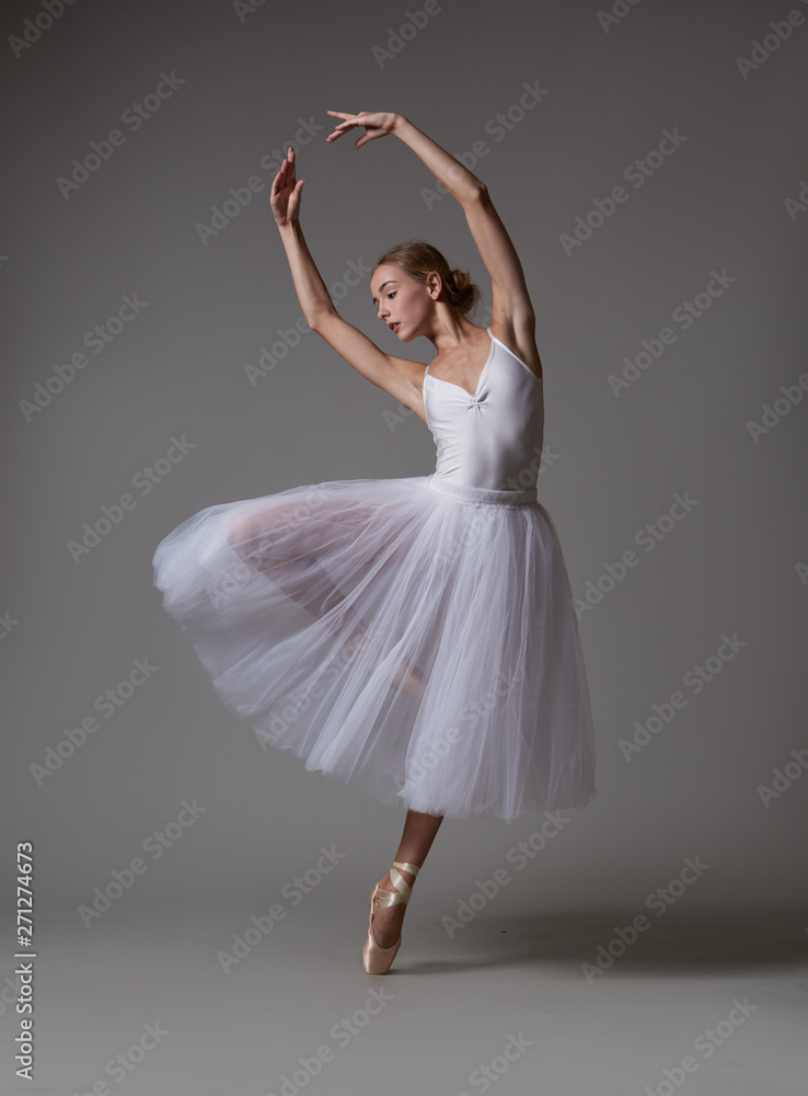Naklejka premium Ballerina dancing in white dress. Color photo.