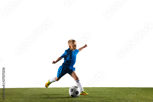 Fototapeta Naklejka Na Ścianę i Meble -  Young boy as a soccer or football player in sportwear making a feint or a kick with the ball for a goal on white studio background. Fit playing boy in action, movement, motion at game.