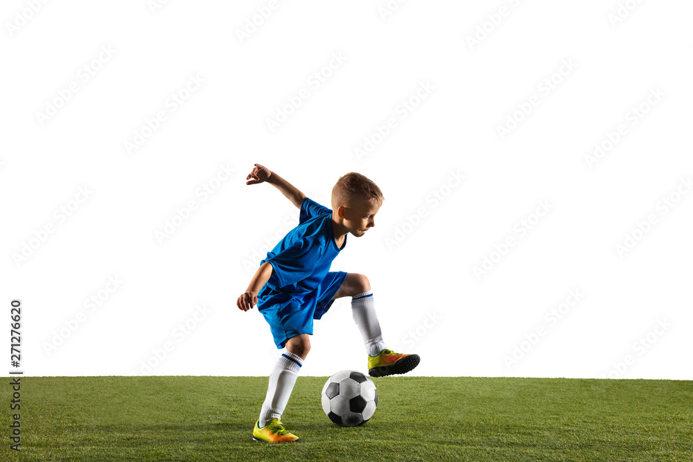 Young boy as a soccer or football player in sportwear making a feint or a kick with the ball for a goal on white studio background. Fit playing boy in action, movement, motion at game. Young boy as a soccer or football player in sportwear making a feint or a kick with the ball for a goal on white studio background. Fit playing boy in action, movement, motion at game.