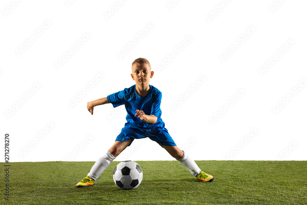 Young boy as a soccer or football player in sportwear making a feint or a kick with the ball for a goal on white studio background. Fit playing boy in action, movement, motion at game.