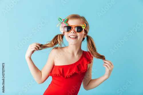 Cheerful little girl wearing swimsuit standing