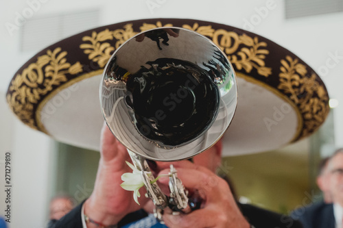 Mexican musician with his trumpet in the foreground, mariachis.