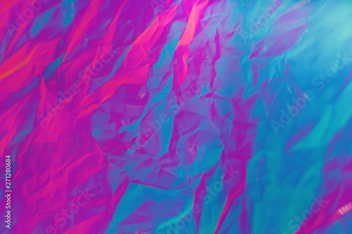 Abstract background of neon colours from crumpled gift paper and backlight