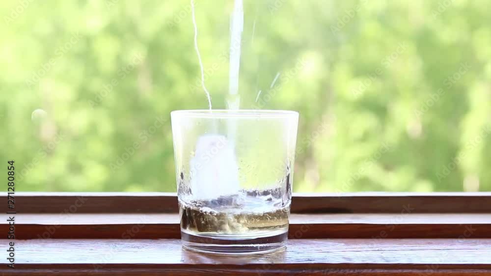 hot water is poured into a glass of tea hot water is poured into a glass of tea