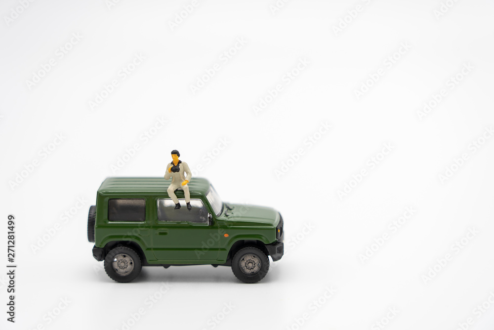 Miniature people standing travel planner with Green toy car model as background travel concept with copy space.