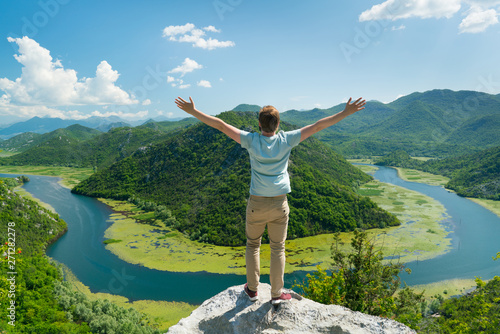 guy posing on the background of a curved river and mountains