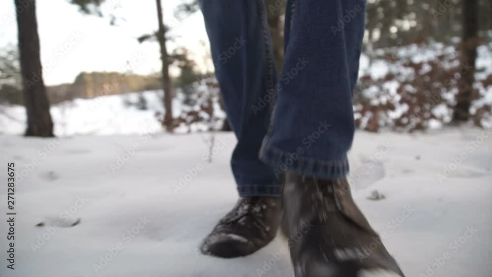 Close-up of man's feet walking on the mountains in the snow. Slow-motion filming Close-up of man's feet walking on the mountains in the snow. Slow-motion filming
