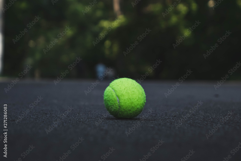 green tennis ball lying on the road