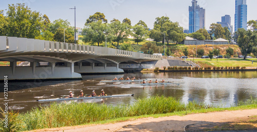 Young boaters on the river Yarra in front of the amazing Melbourne skyline from the shores of the river Yarra, Melbourne, South Australia photo