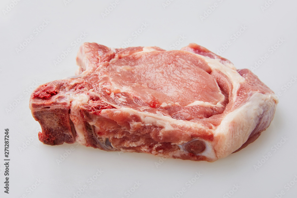 Raw pork loin isolated on white background. Raw fresh pork fillet steak with the bone. Sliced raw pork meat isolated. Raw pork loin isolated on white background. Raw fresh pork fillet steak with the bone. Sliced raw pork meat isolated.