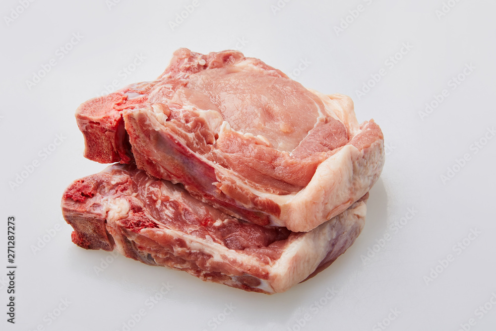 Raw pork loin isolated on white background. Raw fresh pork fillet steak with the bone. Sliced raw pork meat isolated. Raw pork loin isolated on white background. Raw fresh pork fillet steak with the bone. Sliced raw pork meat isolated.