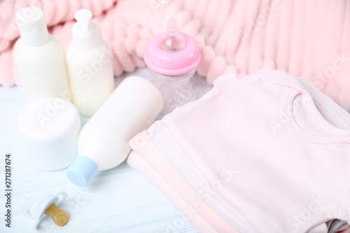 Clothes with baby supplies on white background