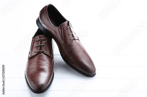 Male leather shoes on white wooden table