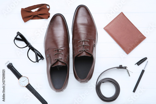 Male leather shoes with accessories on white background
